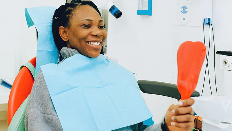 woman at the dentist looking in the mirror