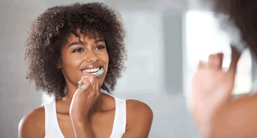 black woman brushing her teeth