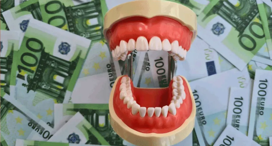 plastic teeth sitting on money