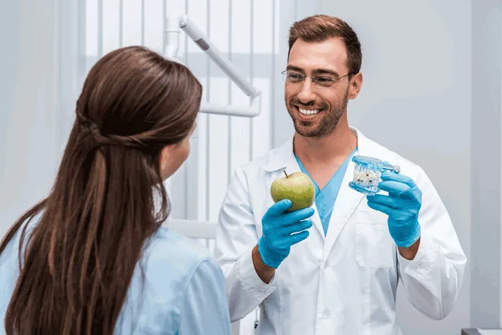 Dr holding fake teeth and apple