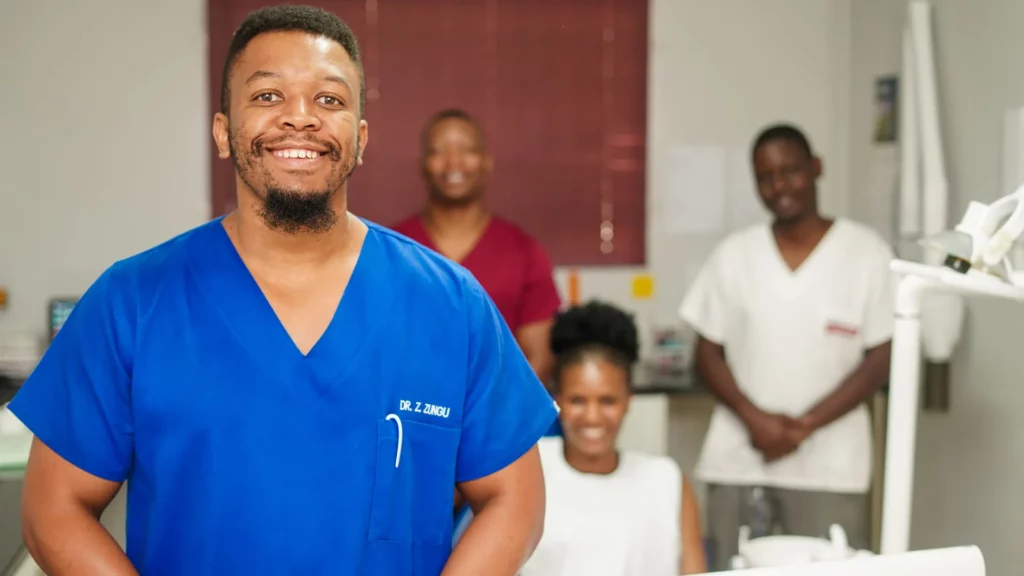 A portrait of Dr Zsazsanov Zungu Smiling with his team at the back